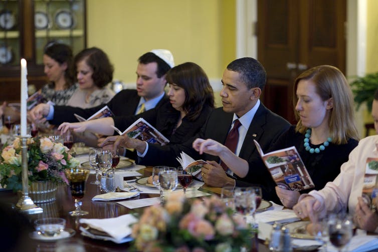 El presidente Obama y sus invitados se sientan alrededor de una mesa en la Casa Blanca.