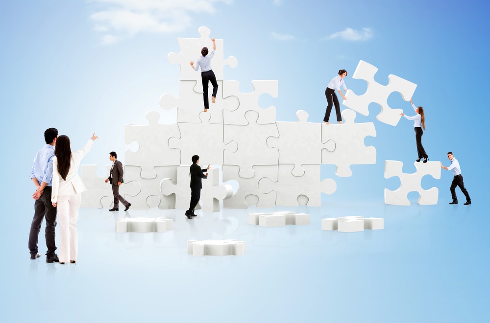 Trabajo en equipo de negocios en acción creando un rompecabezas en la nube